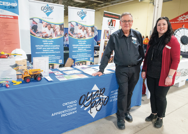 OYAP Coordinator Mark Brotherston & coworker stand at their booth at Build a Dream London inside the Agriplex.